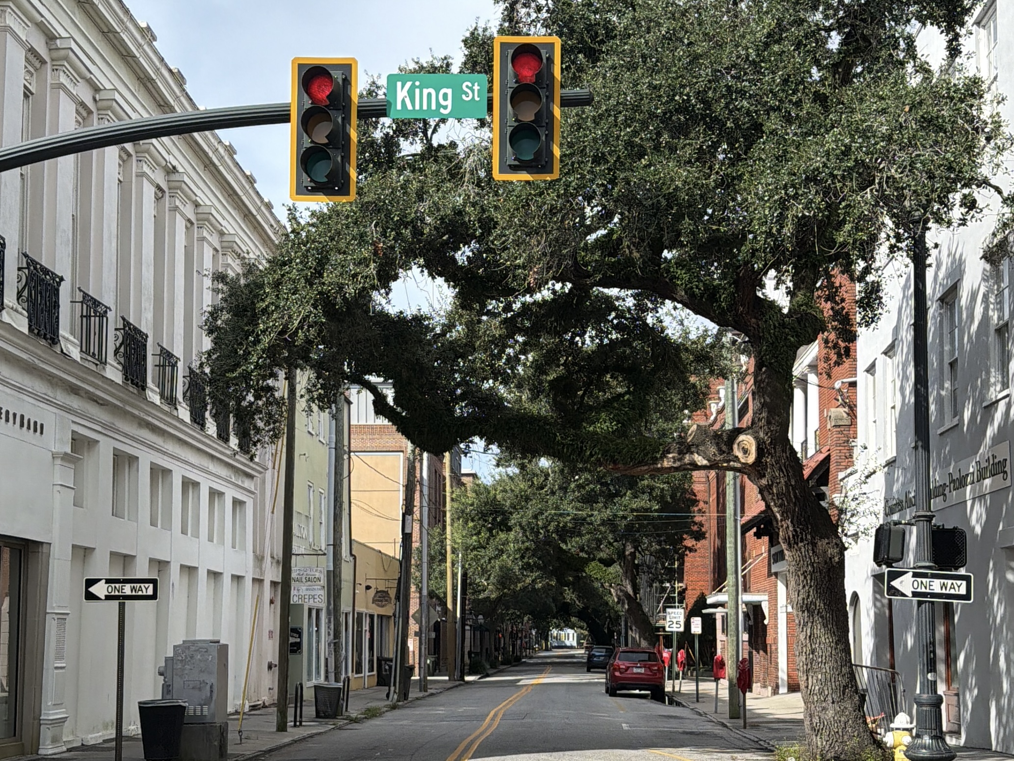 King Street sign in Charleston under a canopy of live oaks, with historic buildings down the block