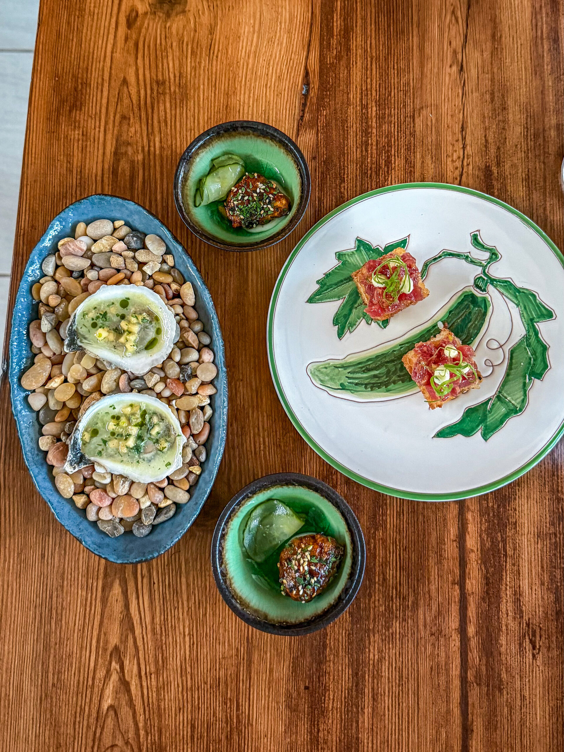 Oysters served on a bed of stones with tuna bites and cucumber at Wild Common in Charleston
